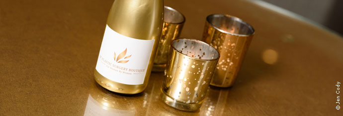 Photograph: Bottle of champagne next to three small glasses